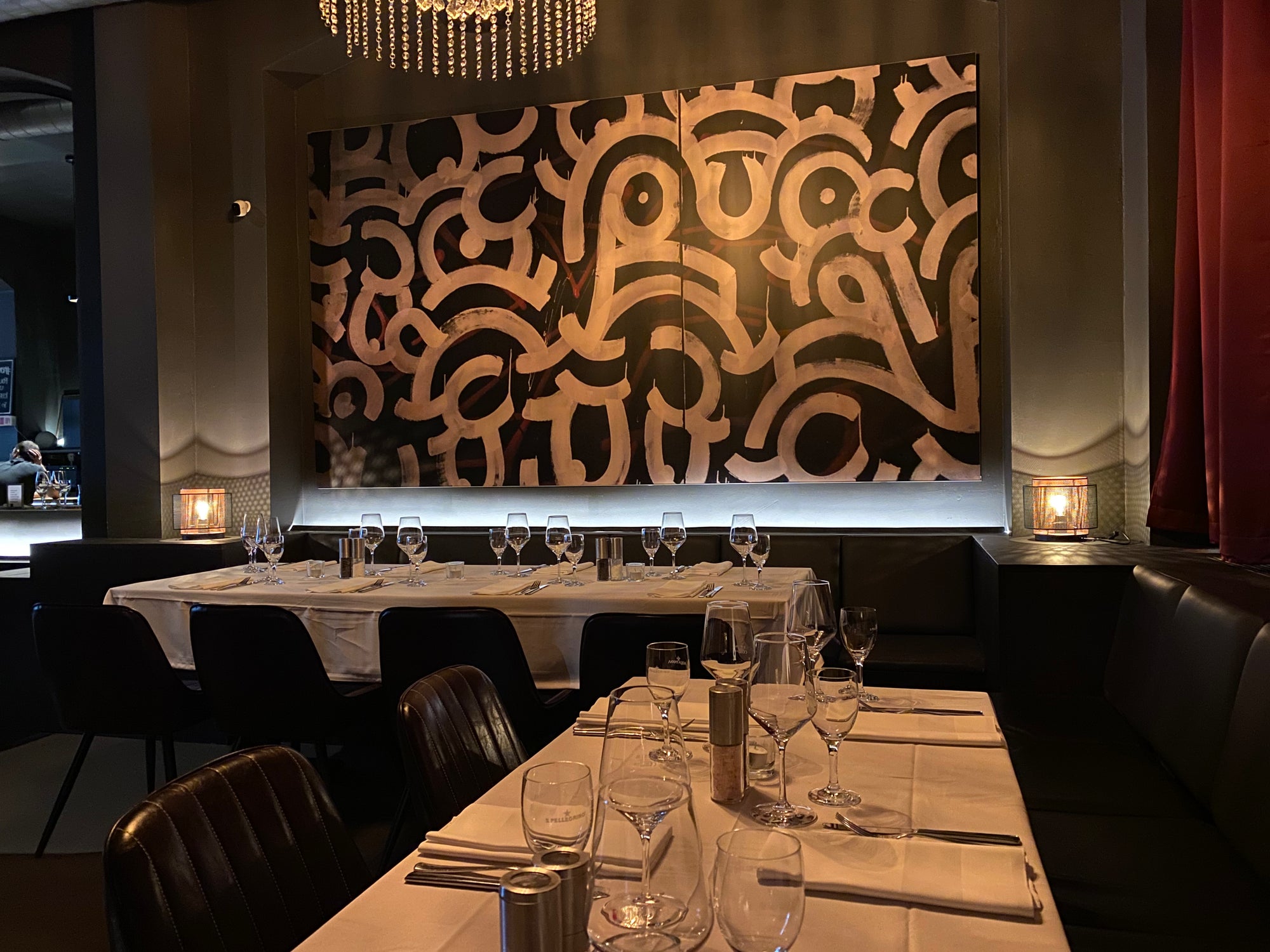 Die lange Tafel in der R10-Lounge, eingedeckt unter der beleuchteten Wandmalerei